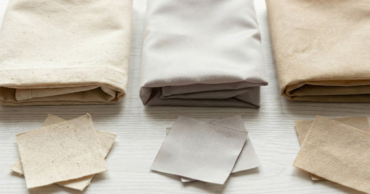 異なる素材（コットン、再生ポリエステルなど）のエコバッグの質感を比較するフラットレイ画像