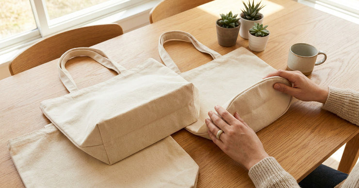 形の異なる複数のトートバッグを机に並べる手元